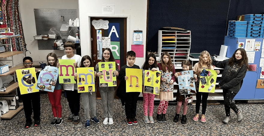 Kids hold art spelling out Community at KAS